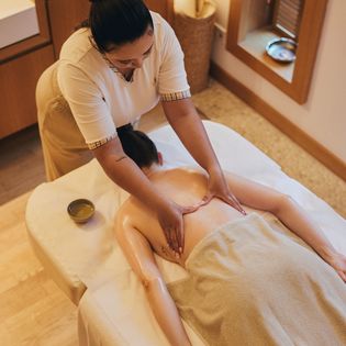 Massage im Severin*s Spa, Keitum, Sylt: Masseurin massiert Rücken einer Person. 