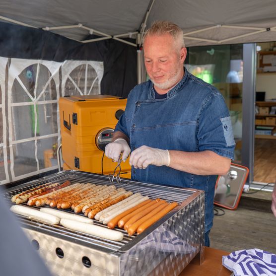 Am Grillstand werden Würstchen verkauft