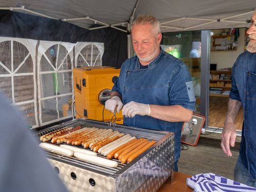 Am Grillstand werden Würstchen verkauft