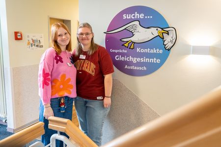 Zwei junge Frauen stehen nebeneinander im Treppenhaus der Klinik.