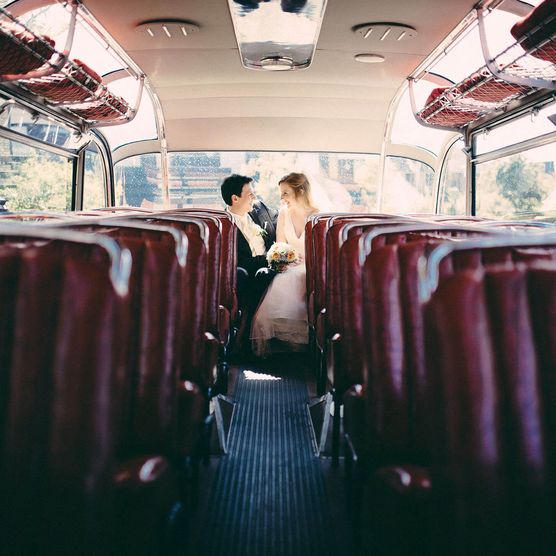 Hochzeitspaar auf dem Rücksitz des Oldtimerbusses auf Sylt