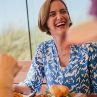 Lächelnde Frau mit Burger und Pommes im Twisters in Wenningstedt.